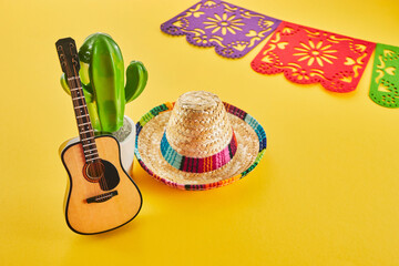 Cinco de Mayo holiday background. Cactus, guitar and hat on yellow background.