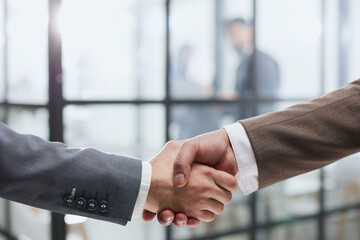 close-up of a handshake of business partners against the background of colleagues