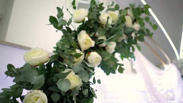 Beautiful wedding arch in flowers of white roses before the wedding ceremony, rose petals