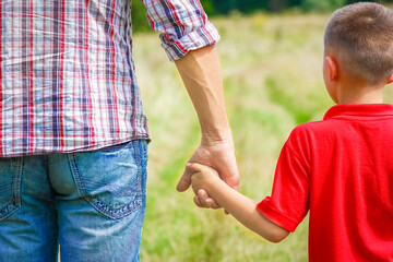 A Hands of happy child and parent on nature in the park family concept