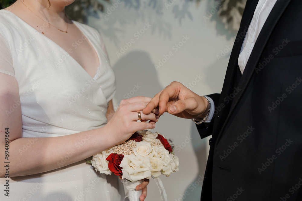 Wall mural Wedding gold rings on the hands of the newlyweds. Gold rings on the hand of a man and a woman