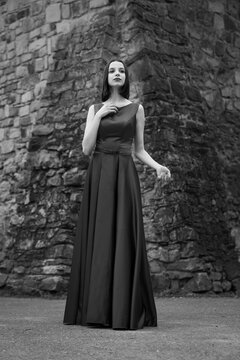Attractive woman in a long dress in front of an old building