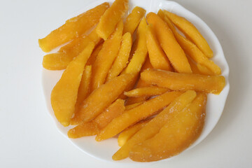 slices of yellow mango closeup photo in plate on white background