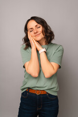 Vertical shot of a woman holding hands together near hear face and eyes closed.