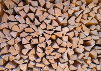 Firewood stacked as background. Dried organic firewood stack