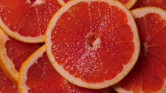 Grapefruit slices rotating. Closeup fruit background. Nobody