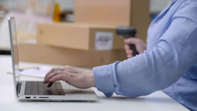 Quality assurance in online sales: Checking product barcodes before delivery to customers for freelance and SME business owners, close up laptop and hand with barcode scanner with boxes