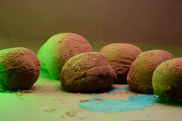 Truffle sweets close-up, green background, studio shot.