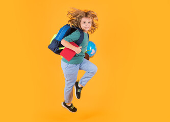 Fototapeta na wymiar Full length body of cheerful school child jumping running back to school isolated over yellow background.