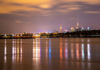 night panorama of warsaw reflected in the wisła river - obrazy, fototapety, plakaty