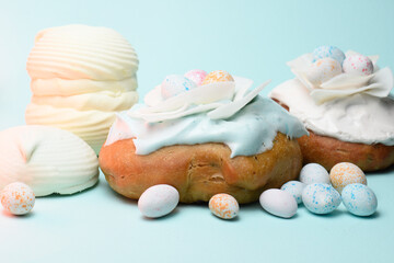 Cake with cream, marshmallows and sweets on a blue background, confectionery.