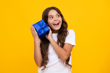 Amazed teen girl. Teenager kid with present box. Teen girl giving birthday gift. Present, greeting and gifting concept. Excited expression, cheerful and glad.