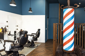 Some characteristic black metal and black leather armchairs in a men's barbershop and the...