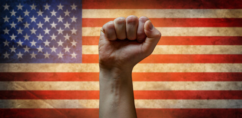 A man's fist against the background of the US flag as a symbol of protest, strike, demonstrations,...