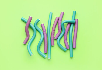 Hair curlers on green background