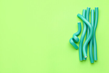 Hair curlers on green background