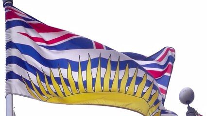 A waving flag of British Columbia in slow motion. A rendition of the Royal Union Flag, defaced in the centre by a crown and with a setting sun, a view from parliament across the water at the province.