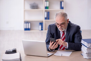 Fototapeta premium Old male employee and too much work in the office