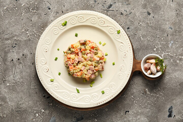 Plate of tasty Olivier salad on grunge background
