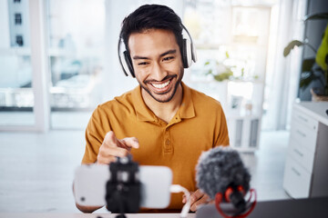 Podcast, pointing and live streaming with a man influencer recording broadcast content in his home...