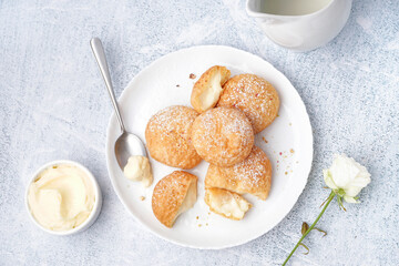 Plate with tasty choux dessert on light background