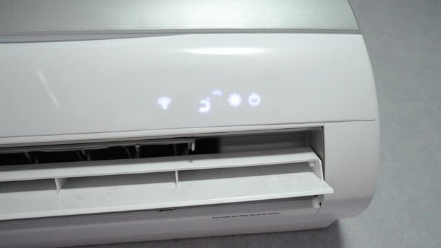 White air conditioner on white wall against background of interior of room is turned on, shows high temperature of 32 degrees, concept of heating room. Heating with warm air.