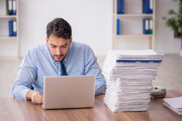 Young male employee and too much work in the office