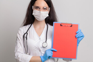 Female doctor holding a blank sheet of paper with space for text