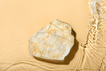 Stone in water on beige background