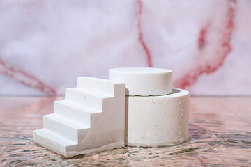 Plaster podiums in water on pink marble background