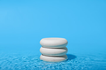 Stack of stones in water on blue background