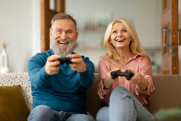 Senior Couple Playing Videogame Online Having Fun Together At Home