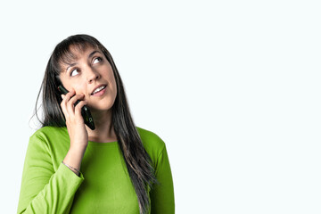 Young woman talking on the phone and looking up with a serious expression on white background