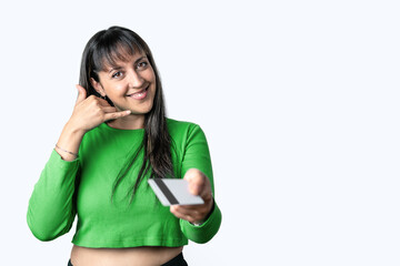 Woman holding a credit card and making phone call gesture on white background