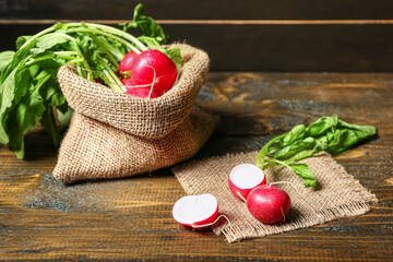 Sack bag of ripe radish with green leaves on table
