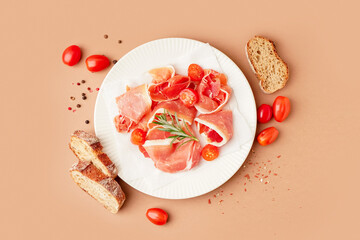 Plate with tasty jamon slices on beige background