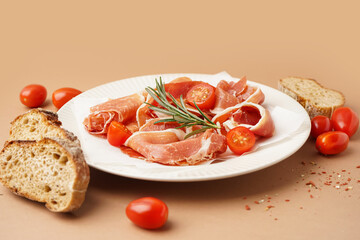 Plate with tasty jamon slices on beige background
