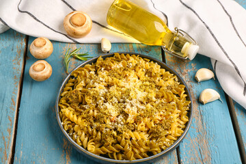 Plate of tasty Italian pasta with Parmesan cheese on blue wooden background
