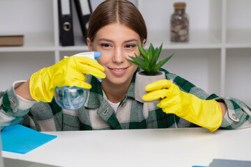 Hand of a woman wiping work desk in yellow gloves