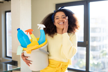 pretty afro black woman feeling happy and astonished at something unbelievable. housekeeper cleaner concept