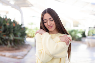 young pretty woman feeling in love, smiling, cuddling and hugging self, staying single, being...