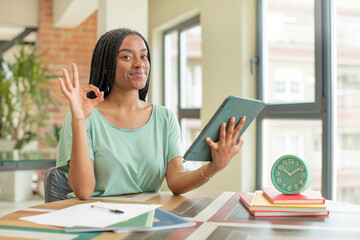 black afro woman feeling happy, showing approval with okay gesture. studying concept