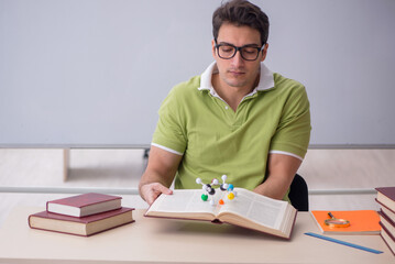 Young male student physicist sitting in the classroom