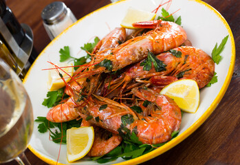 Delicious seafood dish, grilled shrimps served with parsley and lemon