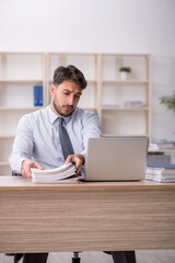 Fototapeta premium Young male employee working in the office