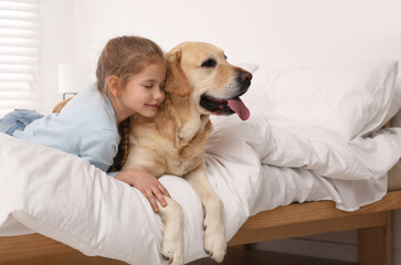 Young girl with her adorable dog on bed at home. Space for text