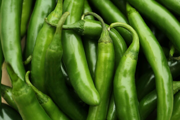 Green hot chili peppers as background, closeup