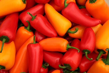 Yellow and red hot chili peppers as background, top view