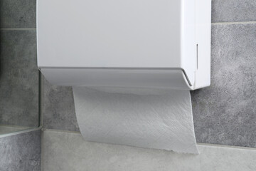 New paper towel dispenser hanging on wall, closeup