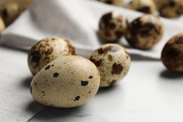 Fototapeta premium Many speckled quail eggs on white table. Space for text
